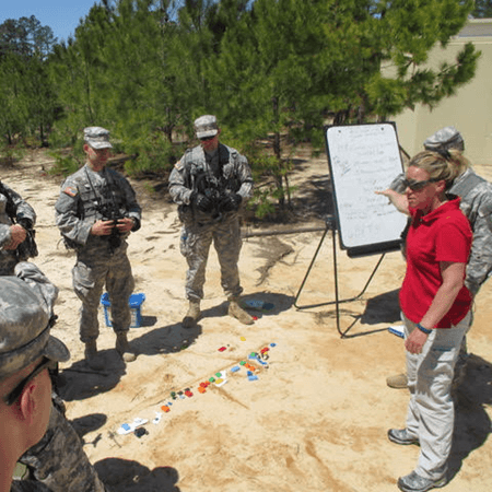Shelly Williams teaching military personnel using a sand table exercise